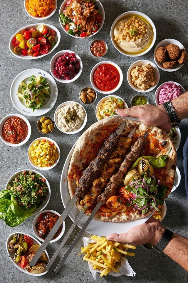 שיפודי קבב טורקי צלויים על פחמים, מונחים על לאפה חמה